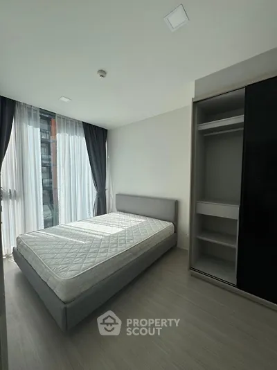 Modern bedroom with natural light and sleek wardrobe in urban apartment
