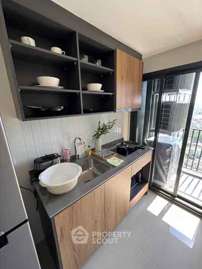 Modern kitchen with sleek cabinets and balcony view, featuring open shelving and contemporary design.
