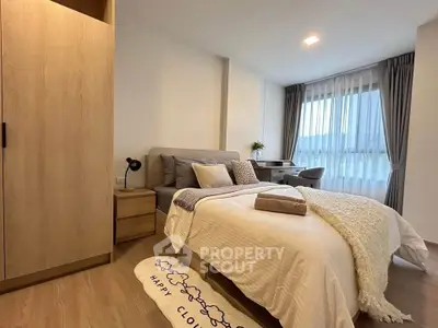 Cozy bedroom with modern decor and large window for natural light