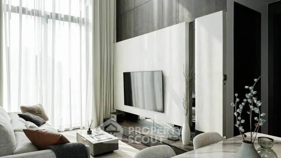 Modern living room with high ceilings, large windows, and stylish decor