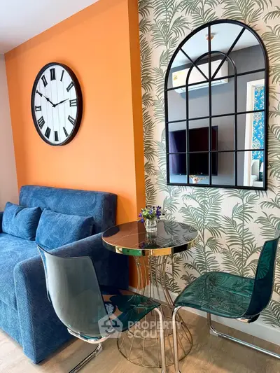 Stylish living room with modern decor, featuring a blue sofa, chic mirror, and vibrant orange accent wall.
