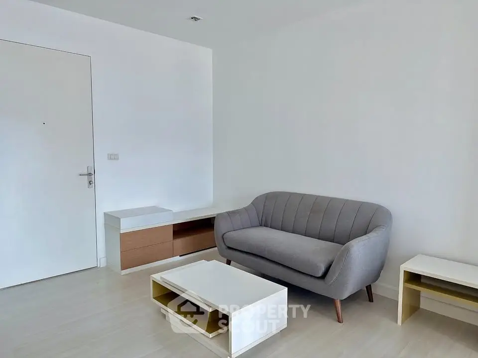 Minimalist living room with modern gray sofa and sleek furniture design.