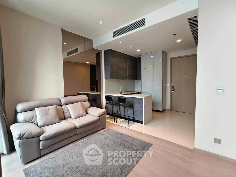 Modern open-layout living room with sleek kitchen and cozy sofa