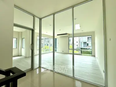 Spacious modern living room with glass walls and abundant natural light