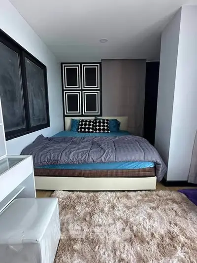 Modern bedroom with stylish decor and cozy ambiance, featuring a plush bed and soft carpet.
