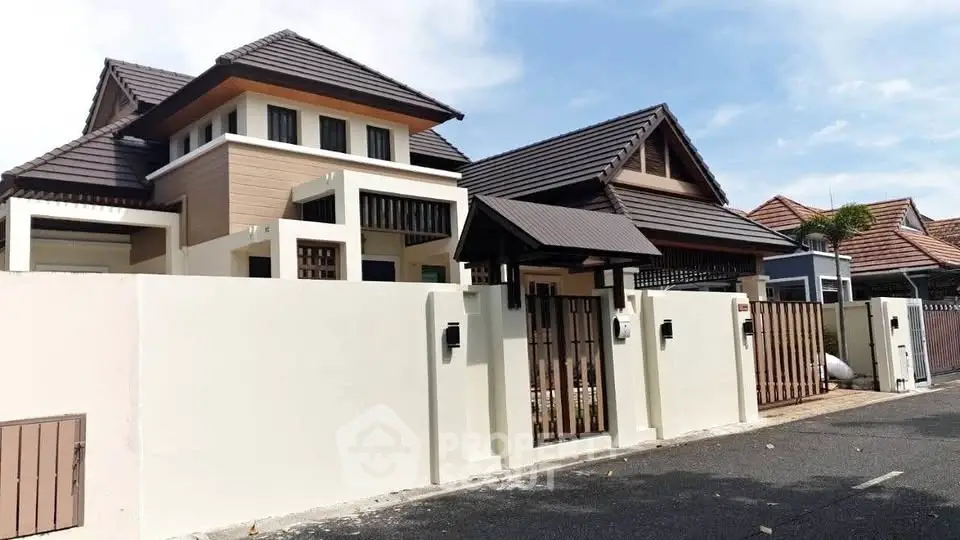 Stunning modern house with elegant roof design and secure gated entrance in a serene neighborhood.