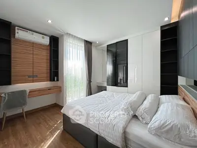Modern bedroom with sleek design, wooden accents, and ample natural light.