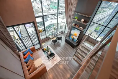 Luxurious high-rise living room with floor-to-ceiling windows and stunning city views.