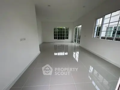 Spacious empty room with large windows and glossy tiled floor
