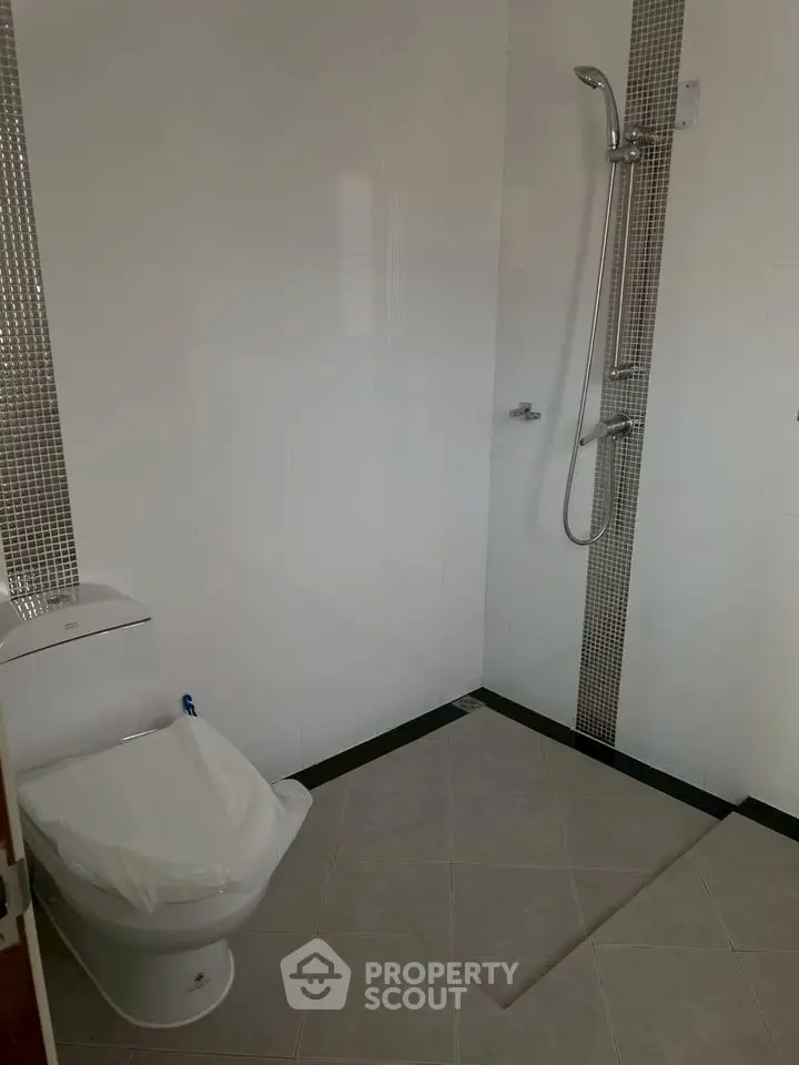 Modern bathroom with sleek shower and toilet in minimalist design