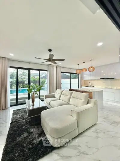 Luxurious living room with pool view, modern furniture, and elegant lighting in a stylish open layout.