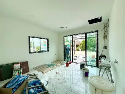 Spacious under-construction living room with large glass doors opening to a garden view.