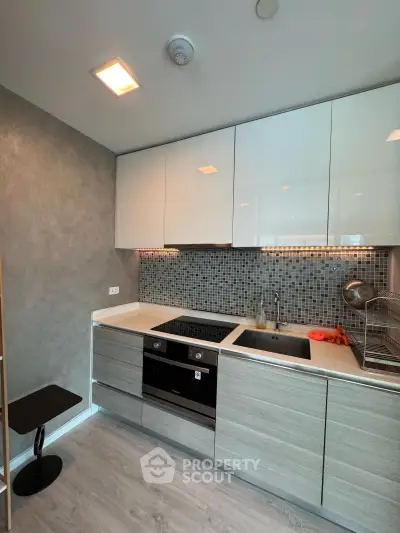 Modern kitchen with sleek cabinetry and built-in appliances in a stylish apartment.