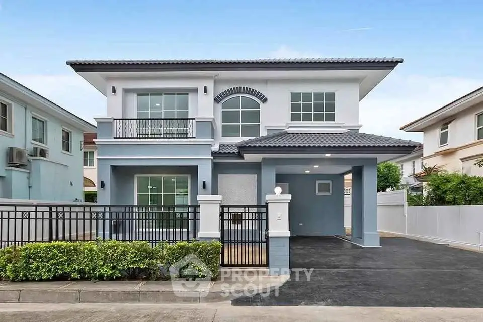 Modern two-story house with sleek design and spacious driveway in a suburban neighborhood.