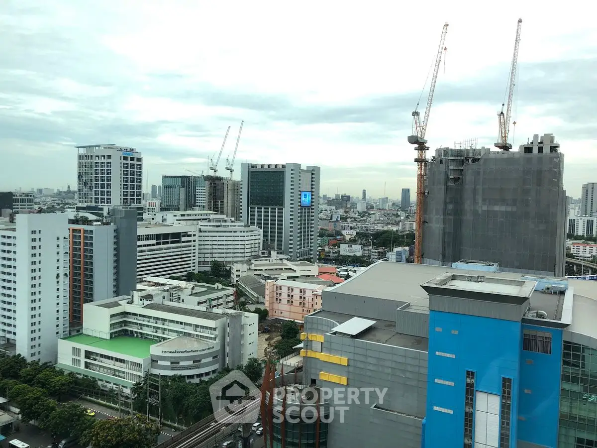 Stunning cityscape view with modern high-rise buildings and construction cranes in a vibrant urban setting.