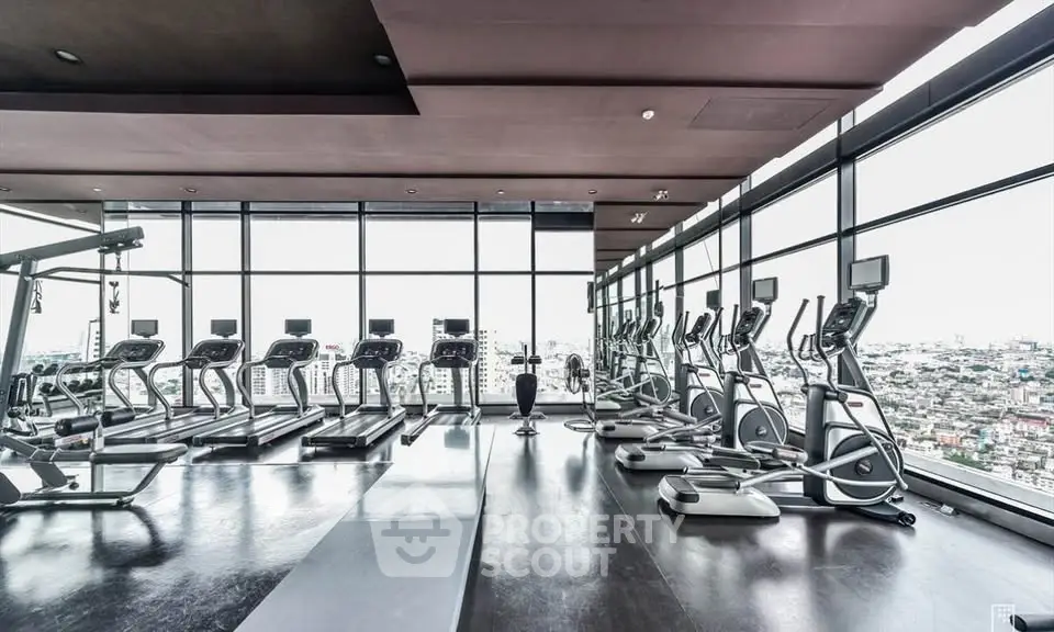 Luxurious high-rise gym with panoramic city views and modern fitness equipment.