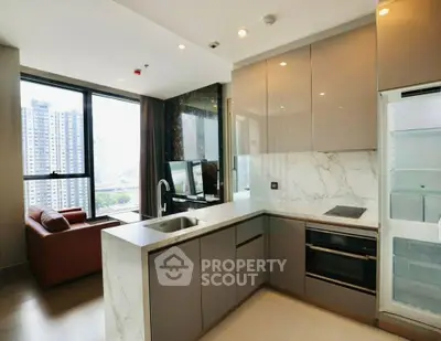Modern open-layout kitchen with sleek appliances and spacious living area in high-rise apartment.