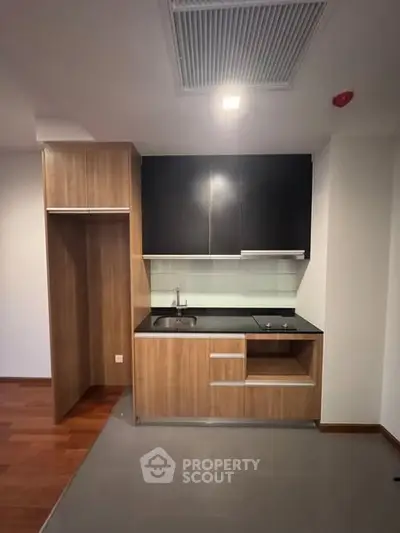 Modern compact kitchen with sleek cabinetry and built-in appliances.
