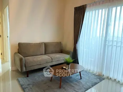 Modern living room with cozy sofa and elegant coffee table near large window with sheer curtains.
