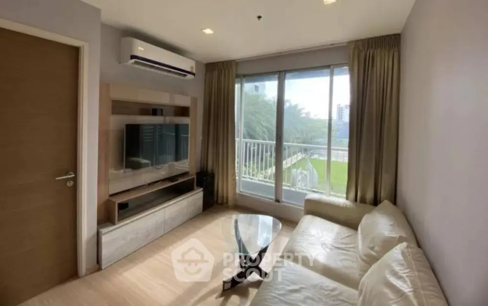 Modern living room with sleek furniture and large window offering a scenic view.