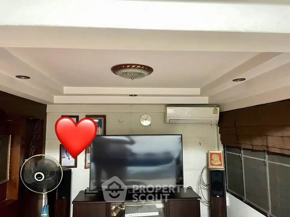 Cozy living room with modern TV setup and air conditioning, perfect for relaxation and entertainment.