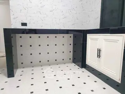 Modern kitchen with sleek black and white tile design and built-in cabinetry.