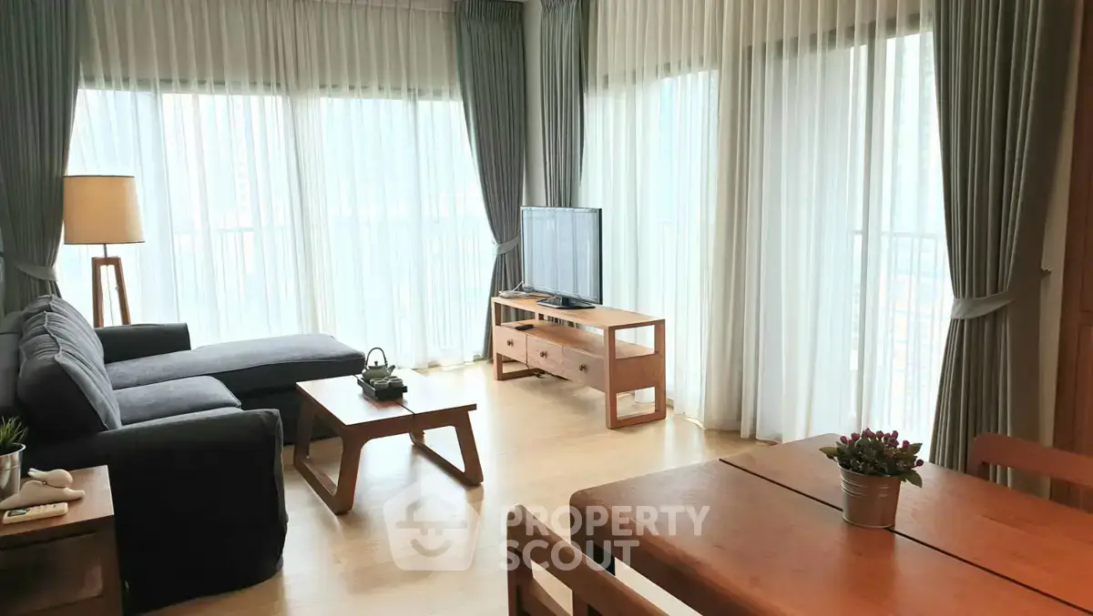 Spacious living room with modern furniture and large windows offering natural light.