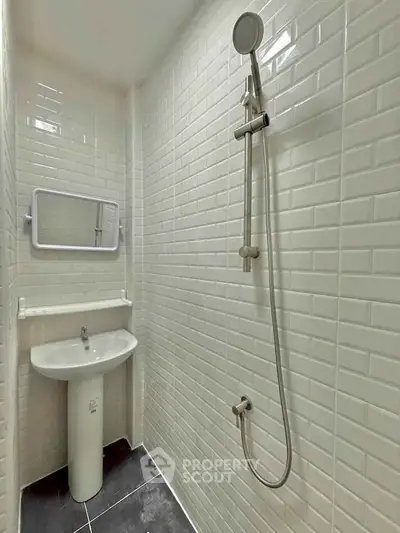 Compact bathroom with sleek white tiles and modern shower design