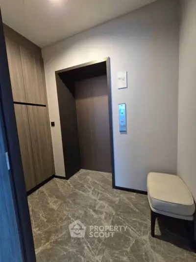Modern elevator lobby with sleek design and comfortable seating in a residential building.