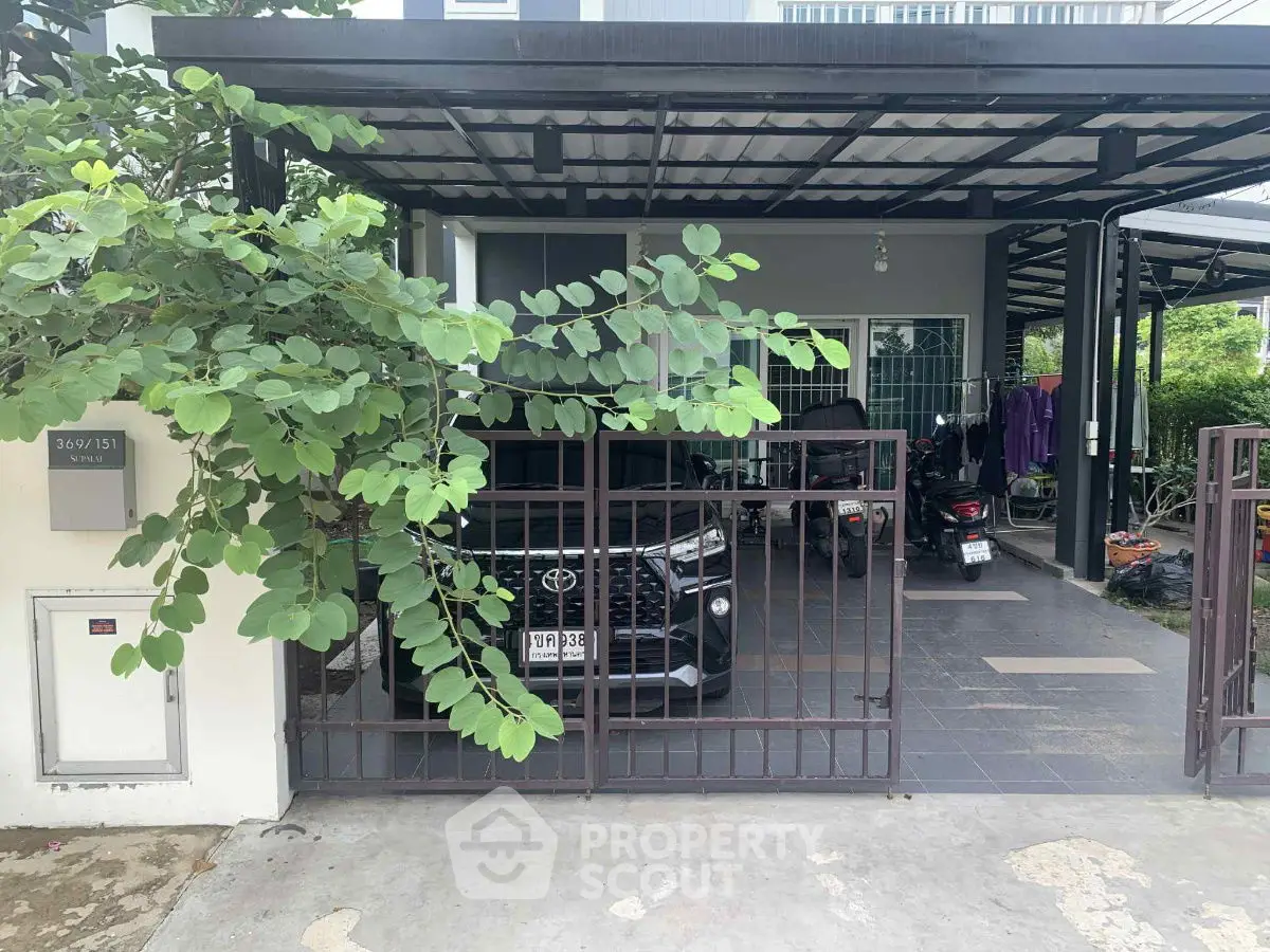 Modern carport with vehicle and lush greenery in a residential area