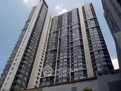 Modern high-rise residential building with sleek design and large windows in urban setting.