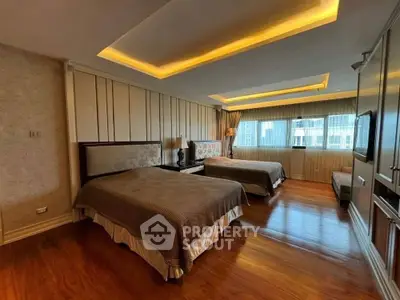Spacious bedroom with two beds and elegant lighting in a modern apartment.