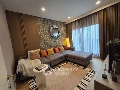 Modern living room with stylish decor and large sectional sofa, featuring floor-to-ceiling windows and elegant lighting.
