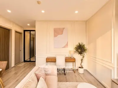 Elegant living room with modern decor and natural light, featuring a cozy sofa and stylish desk.