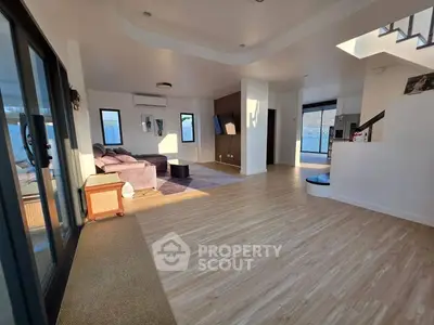 Spacious modern living room with elegant flooring and ample natural light