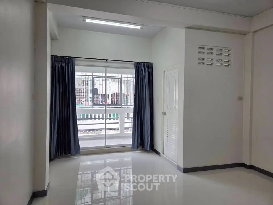 Spacious empty room with large window and glossy floor, ideal for customization.