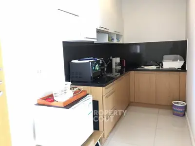 Modern kitchen with sleek cabinets and black backsplash in a compact layout.