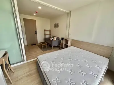 Modern studio apartment with cozy living area and comfortable bed, perfect for urban living.