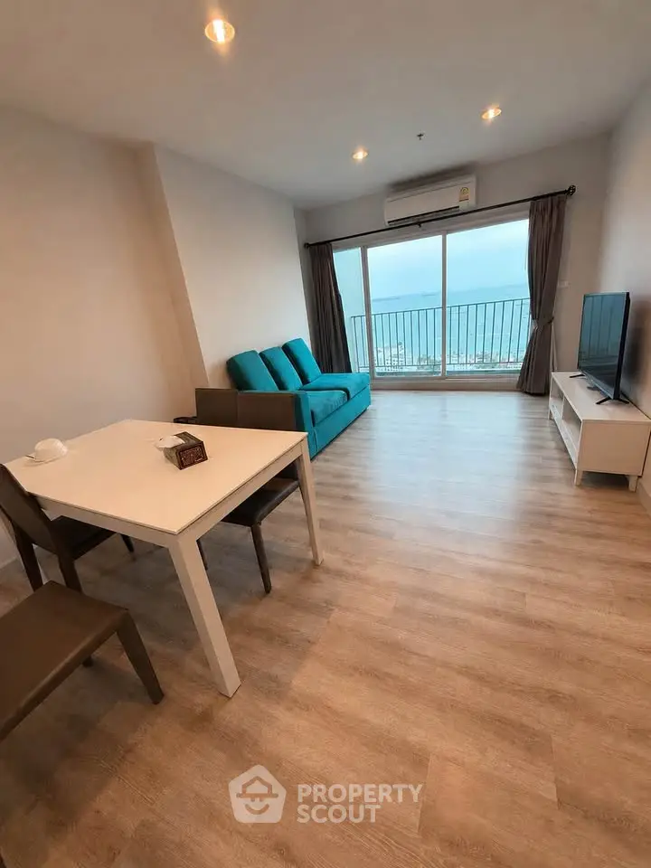 Modern living room with ocean view, featuring sleek furniture and large windows for natural light.