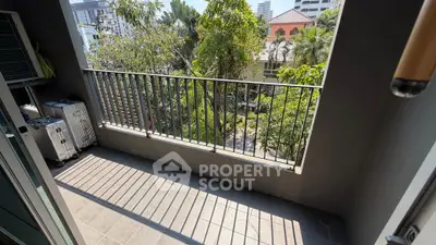 Spacious balcony with lush garden view in urban setting