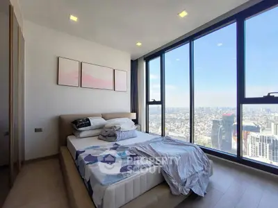Stunning bedroom with floor-to-ceiling windows offering panoramic city views.
