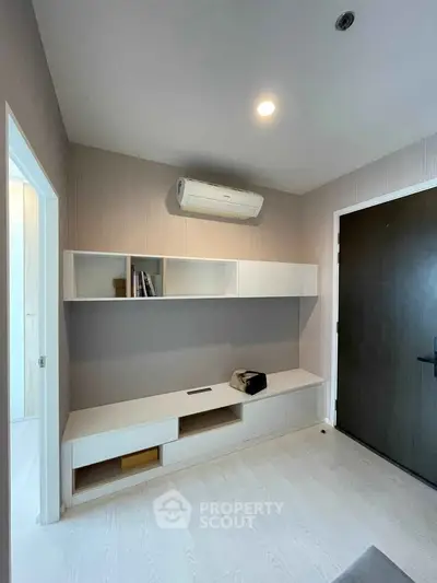 Modern minimalist living room with built-in shelving and air conditioning