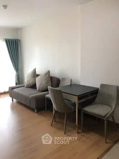 Modern living room with cozy sofa and dining area, featuring elegant decor and natural light.