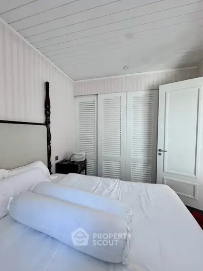 Cozy bedroom with elegant white decor and ample closet space