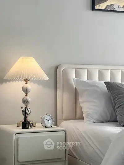 Elegant bedroom with plush headboard and stylish bedside lamp