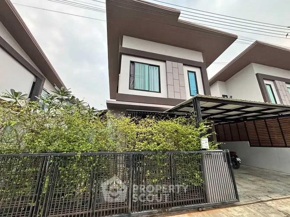 Modern two-story house with sleek design and covered parking in a serene neighborhood.