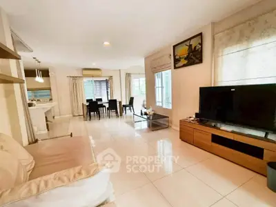 Spacious living room with modern decor and large TV, perfect for family gatherings.