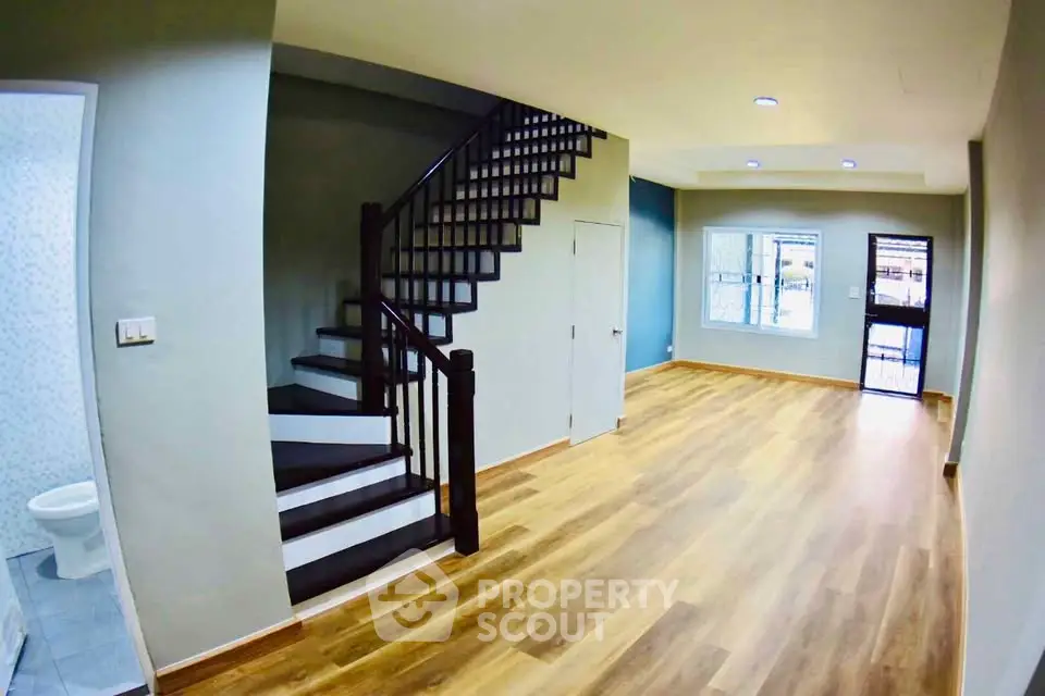 Spacious modern living room with wooden flooring and staircase