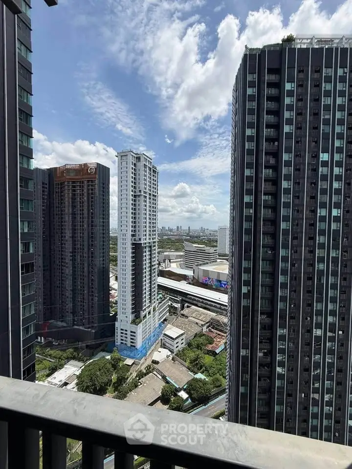 Stunning cityscape view from high-rise balcony with modern skyscrapers and clear blue sky.