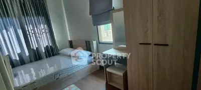 Cozy bedroom with natural light, featuring a single bed, wardrobe, and study desk.